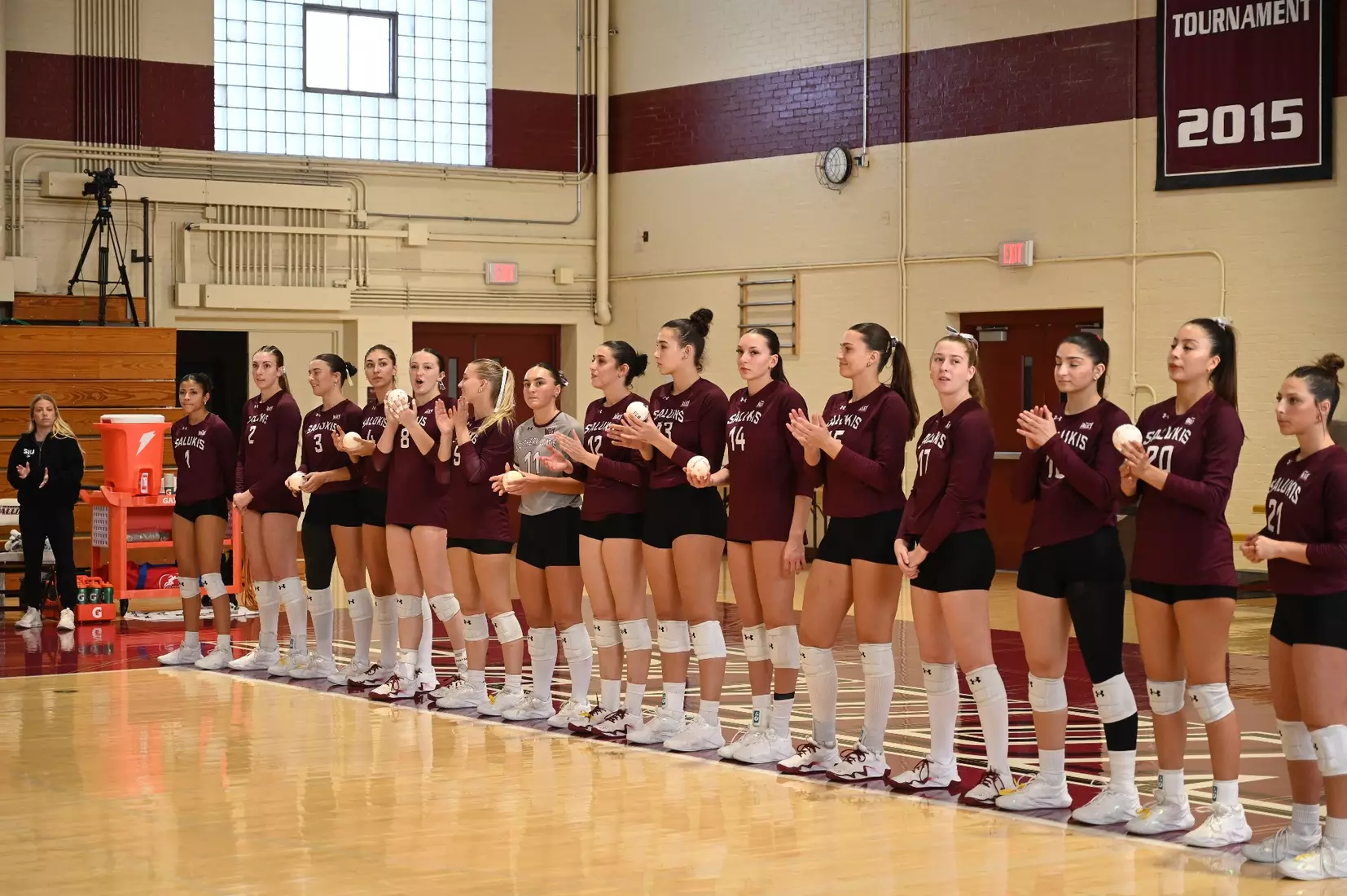 The team claps as the opposing team is introduced.