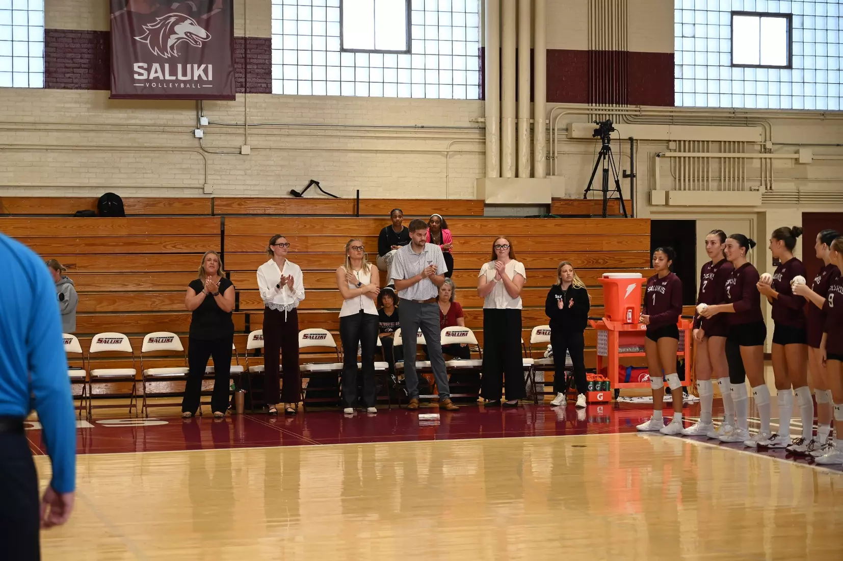 The coaches clap during introductions.