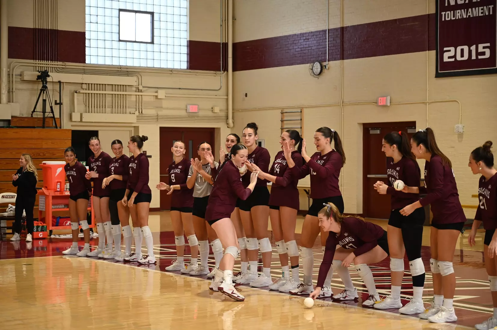 Alexandria Arrington high fives her teammates and drops her ball as her name is announced.