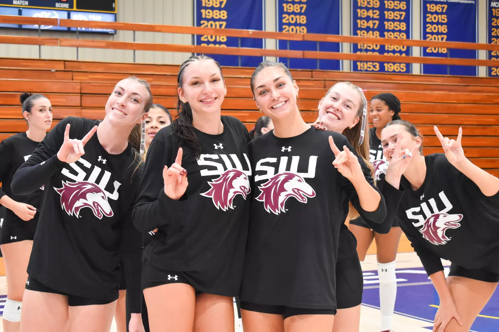 Members of the team smile and put dog ears up for a picture.