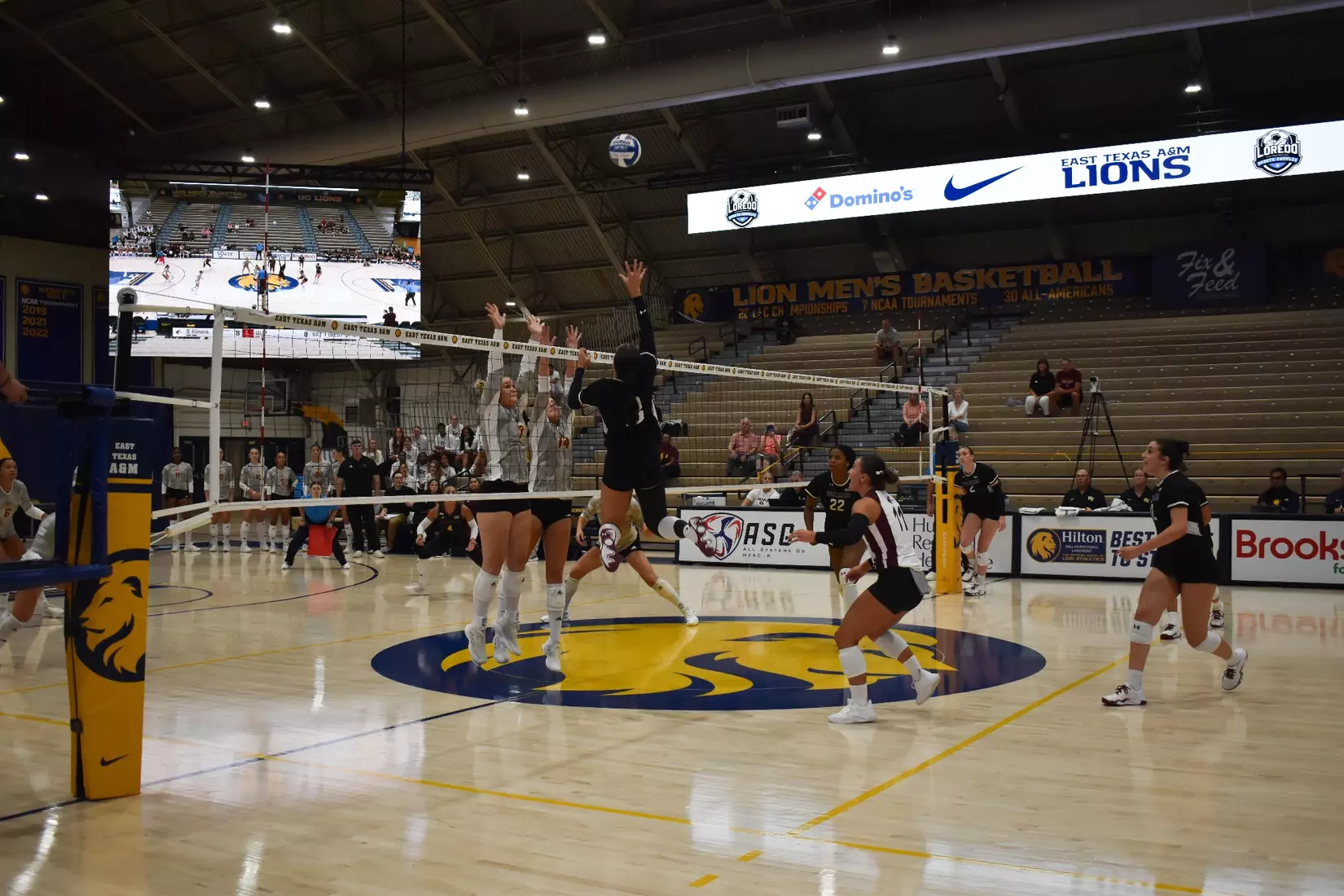 McKenzie Moeller tips a ball over the outstretched arms of two Warhawks.