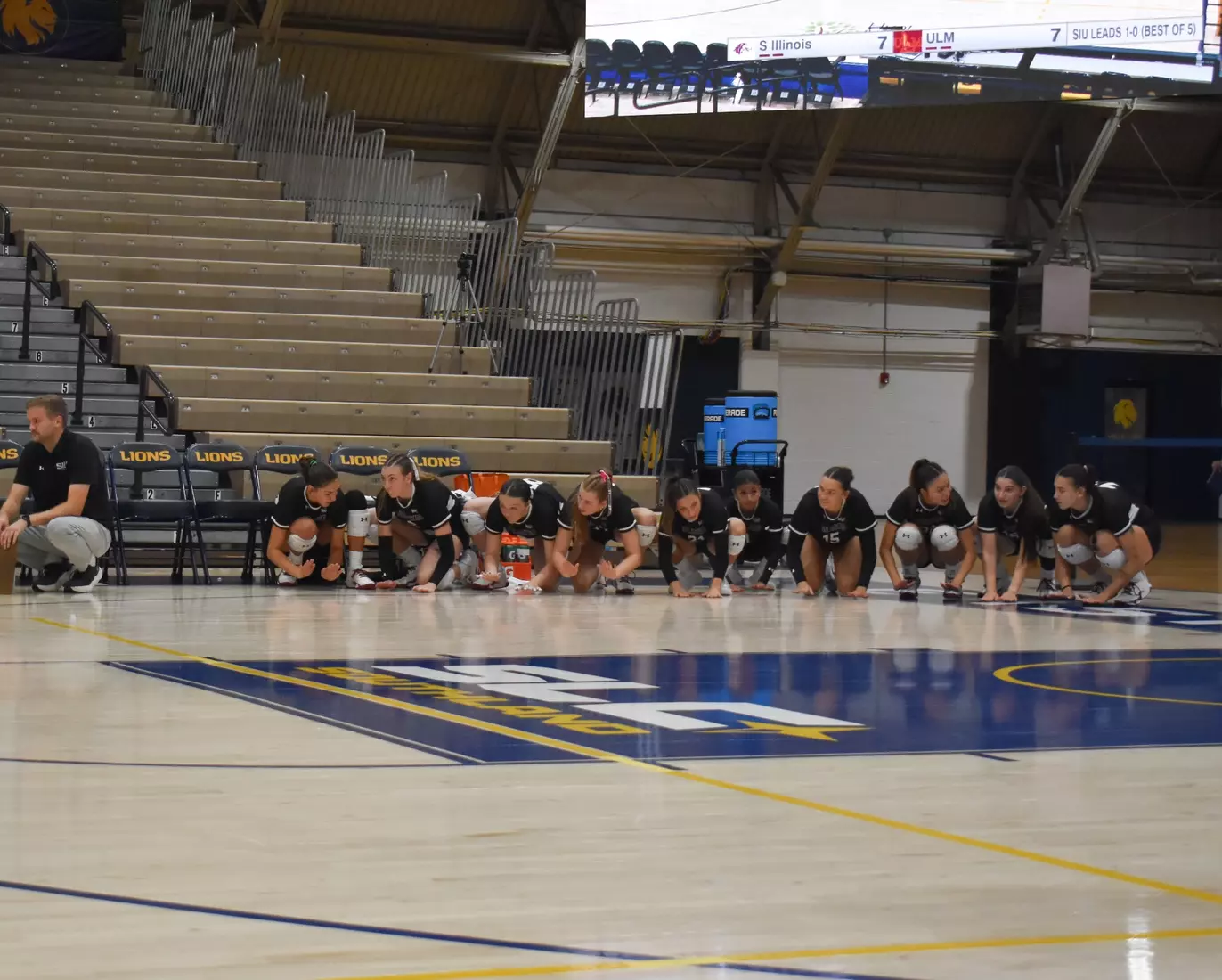 The bench smacks the floor to hype up the team on the court.