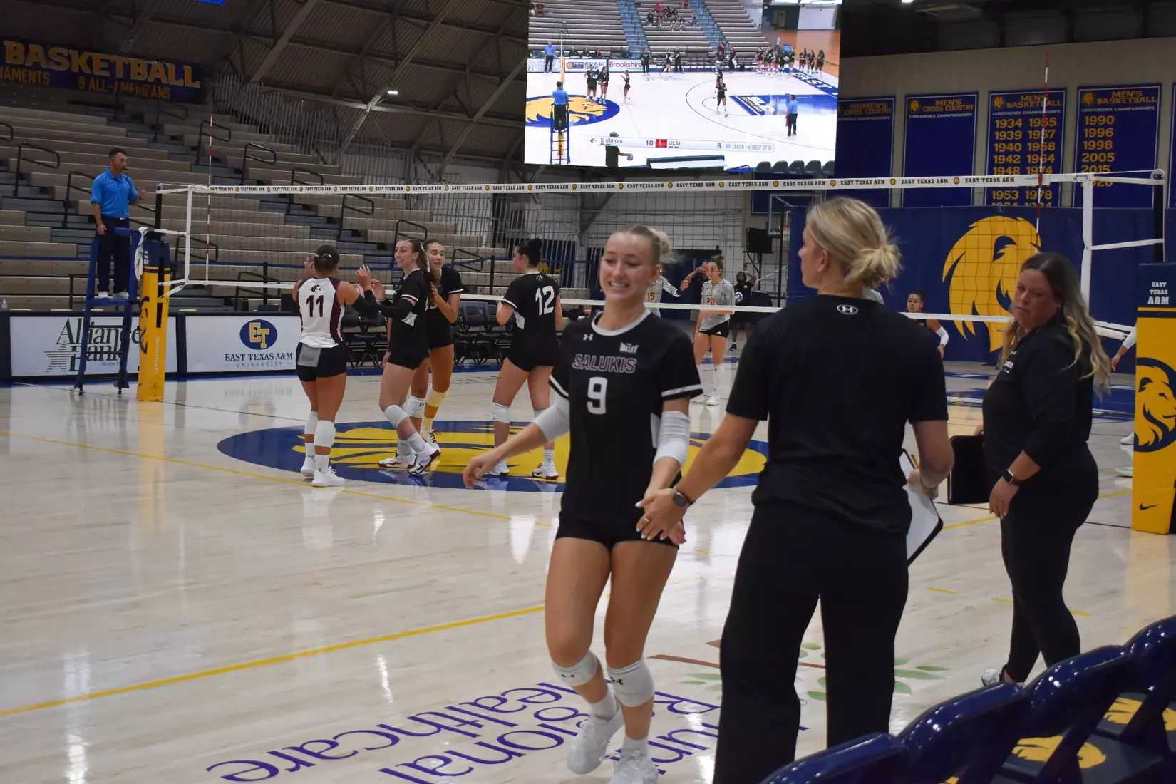 Lillian Dempkey high fives graduate assistant Emma Lade.