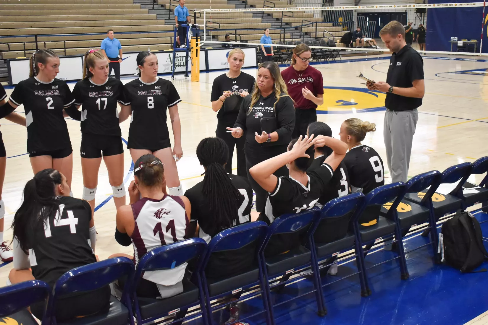 Head Coach Brittany Harry talks to her team in between sets.