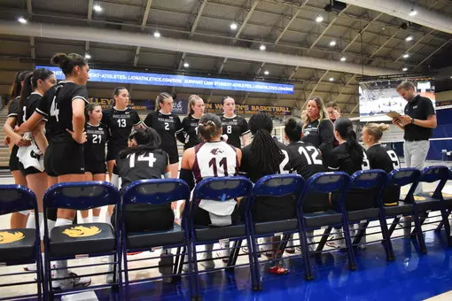 Head Coach Brittany Harry talks to her team in between sets.