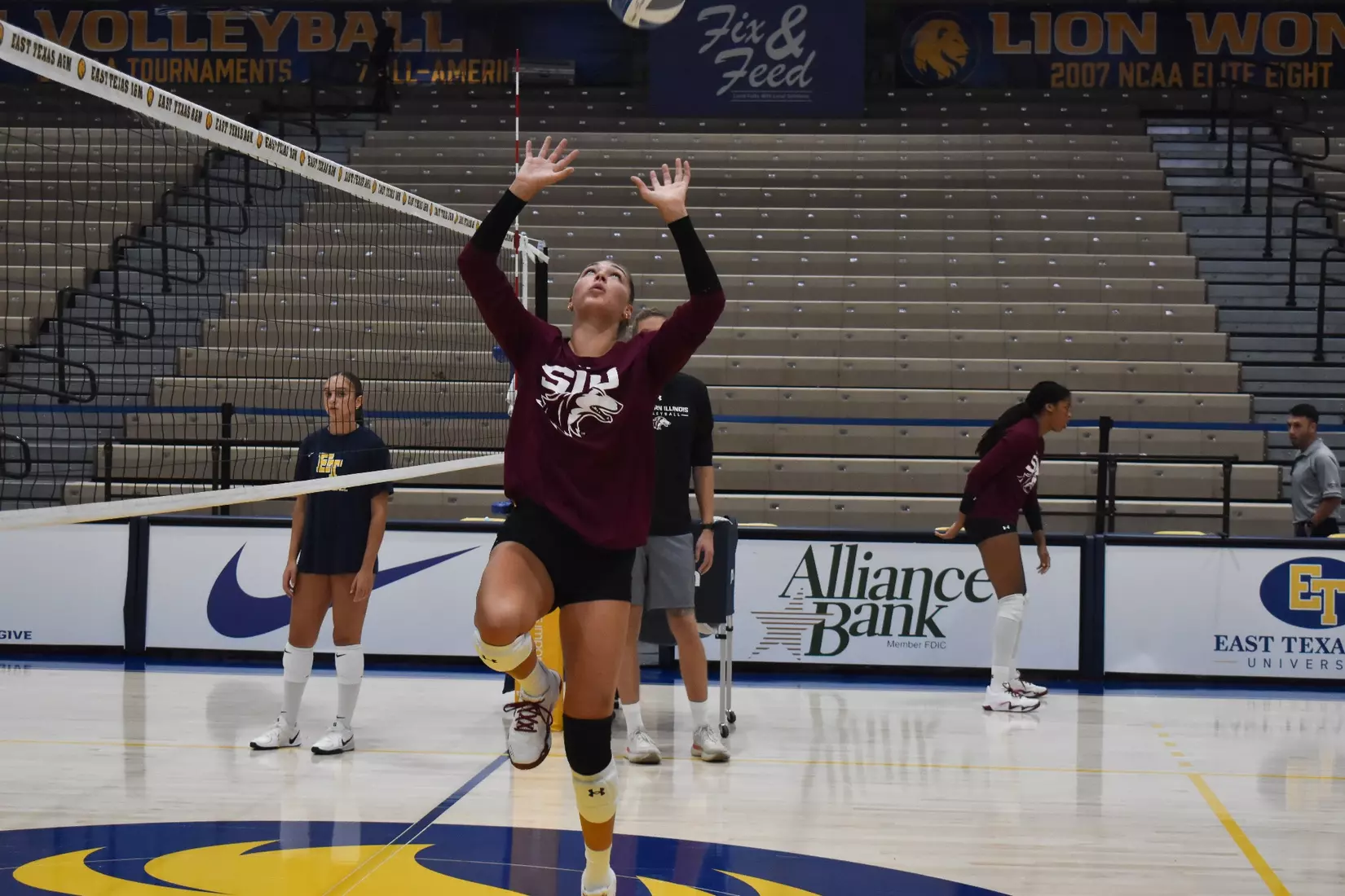 Ella McFarland jumps up to set a ball in warmups.