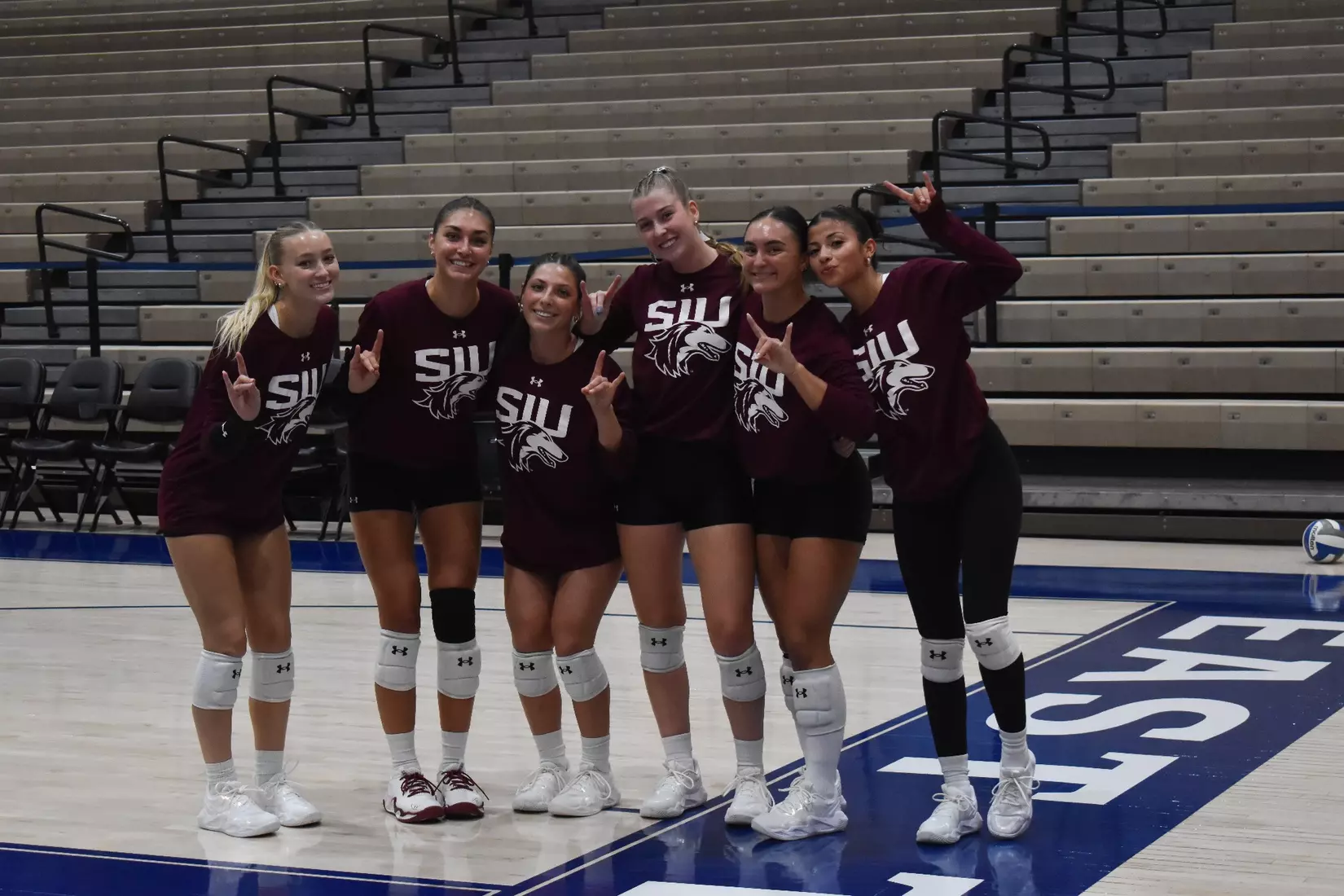 Members of the team smile for a picture in warmups.