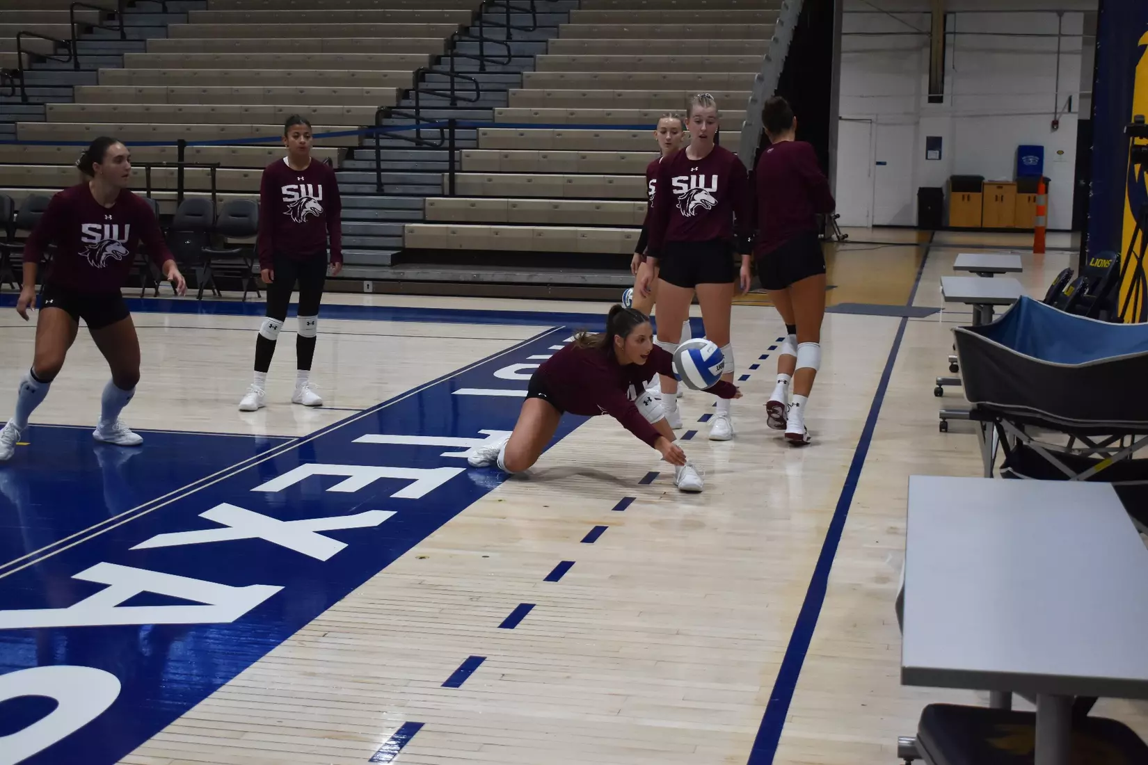 Isabella Del Real lunges for a ball in warmups.