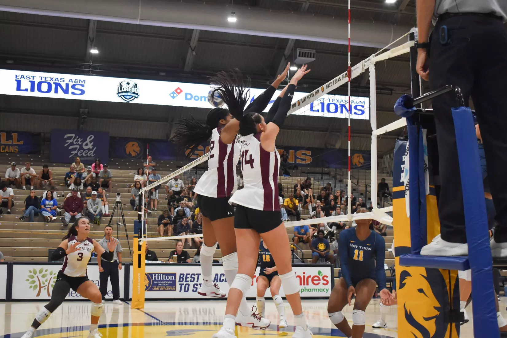 Chloe Anderson and Ella Swansiger jump up to block an incoming attack.