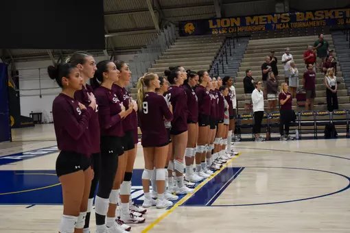 The Salukis stand in unison with their hands on their hearts during the national anthem.