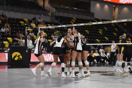 The Saluki Women's Volleyball team huddles and celebrates after a point.