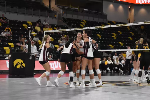 The Saluki Women's Volleyball team huddles and celebrates after a point.