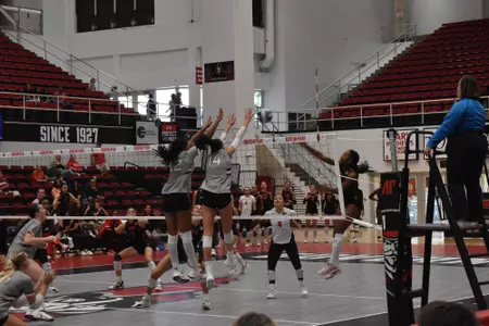 Chloe Anderson and Ella Swansiger go up for a block on an opposing attack.