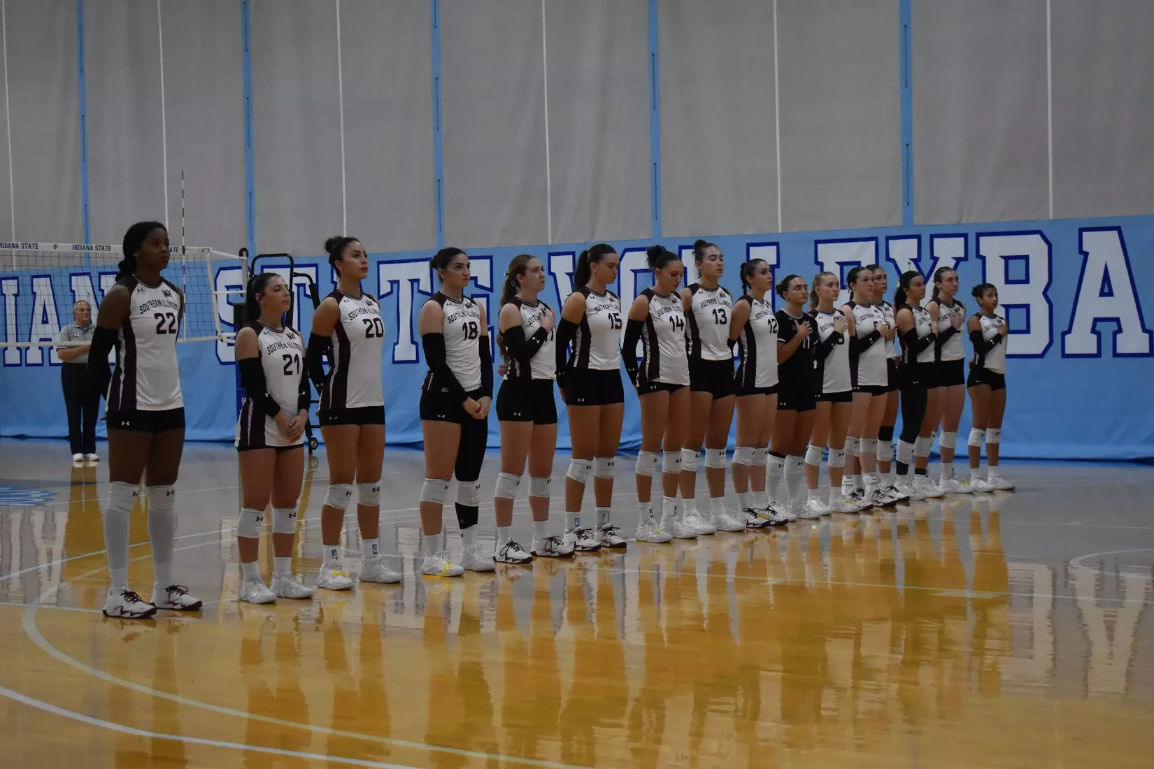 The team stands together during the national anthem.