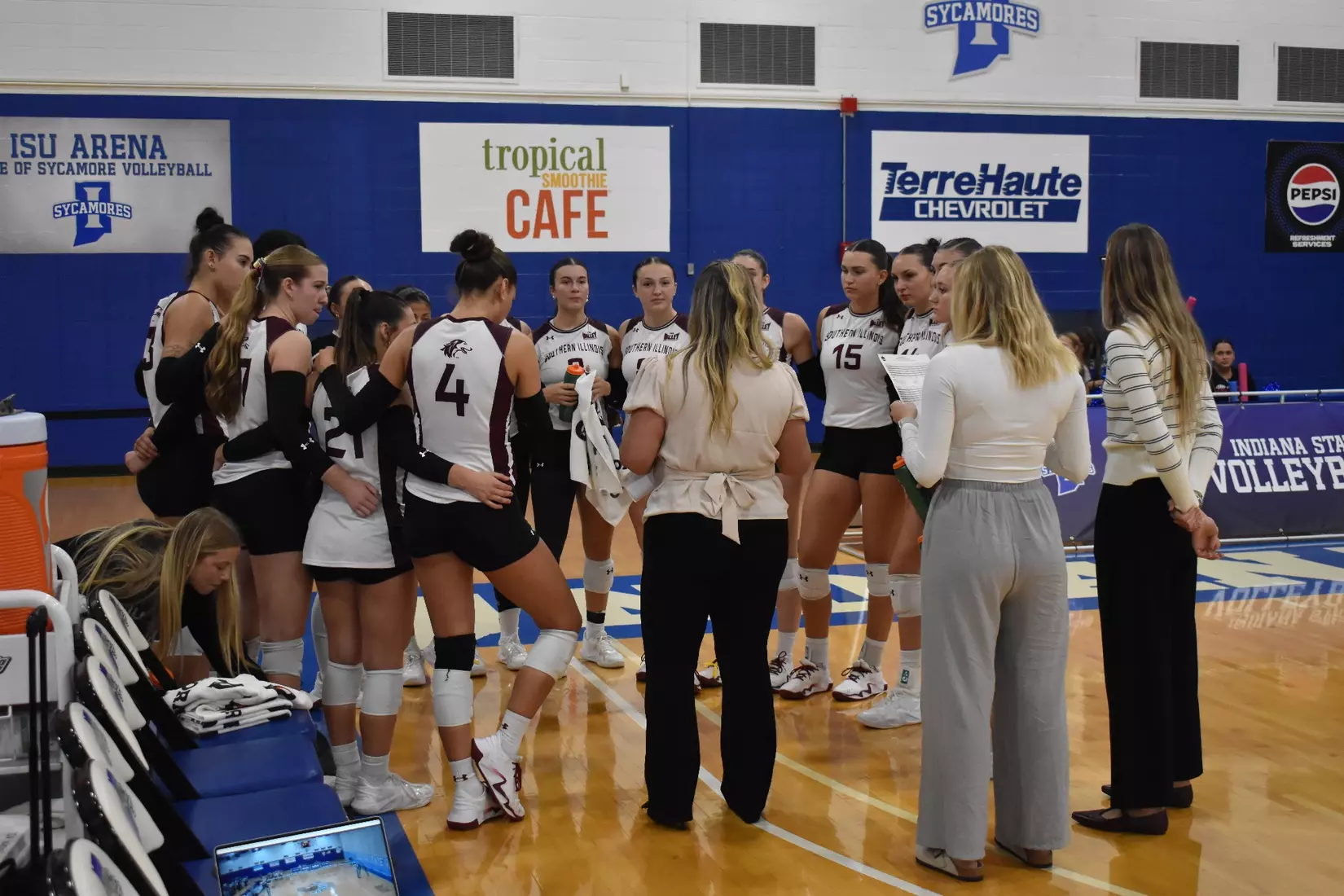 Head Coach Brittany Harry talks to her team in between sets.