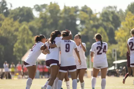 Women's soccer team hugging after scored goal