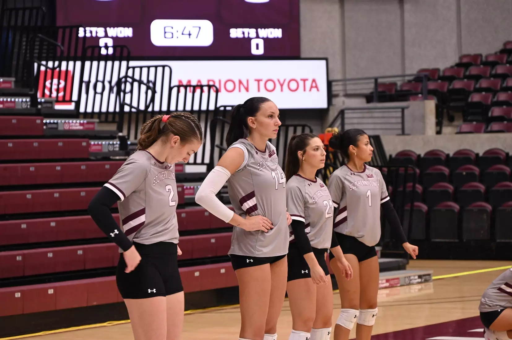 Members of the team stand by and watch the opponent's warmups.