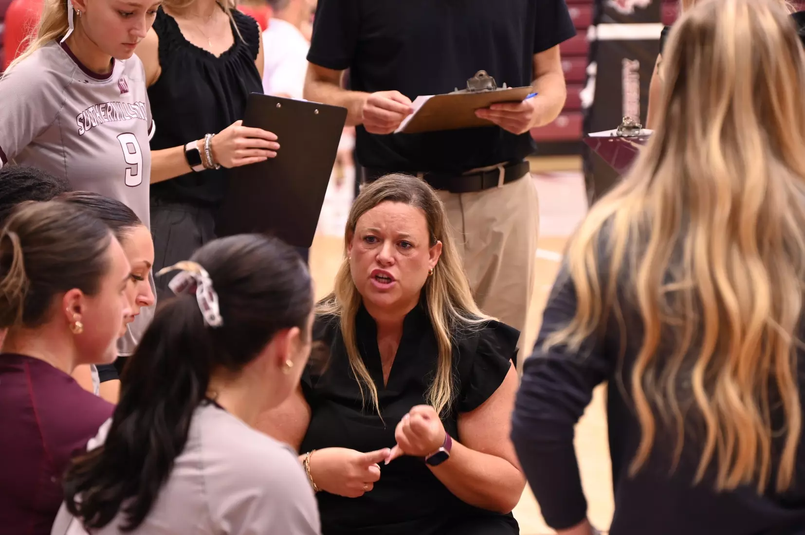Head Coach Brittany Harry talks to her team during a timeout.