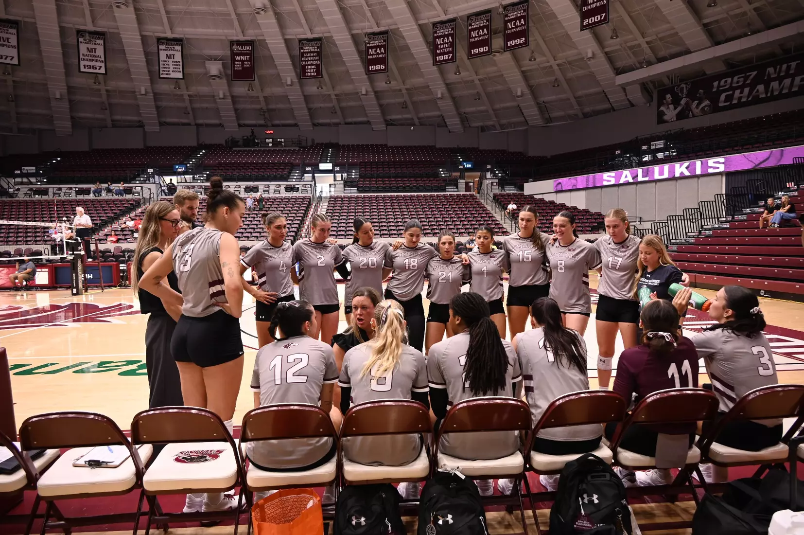 The team and Head Coach Brittany Harry discuss during a timeout.