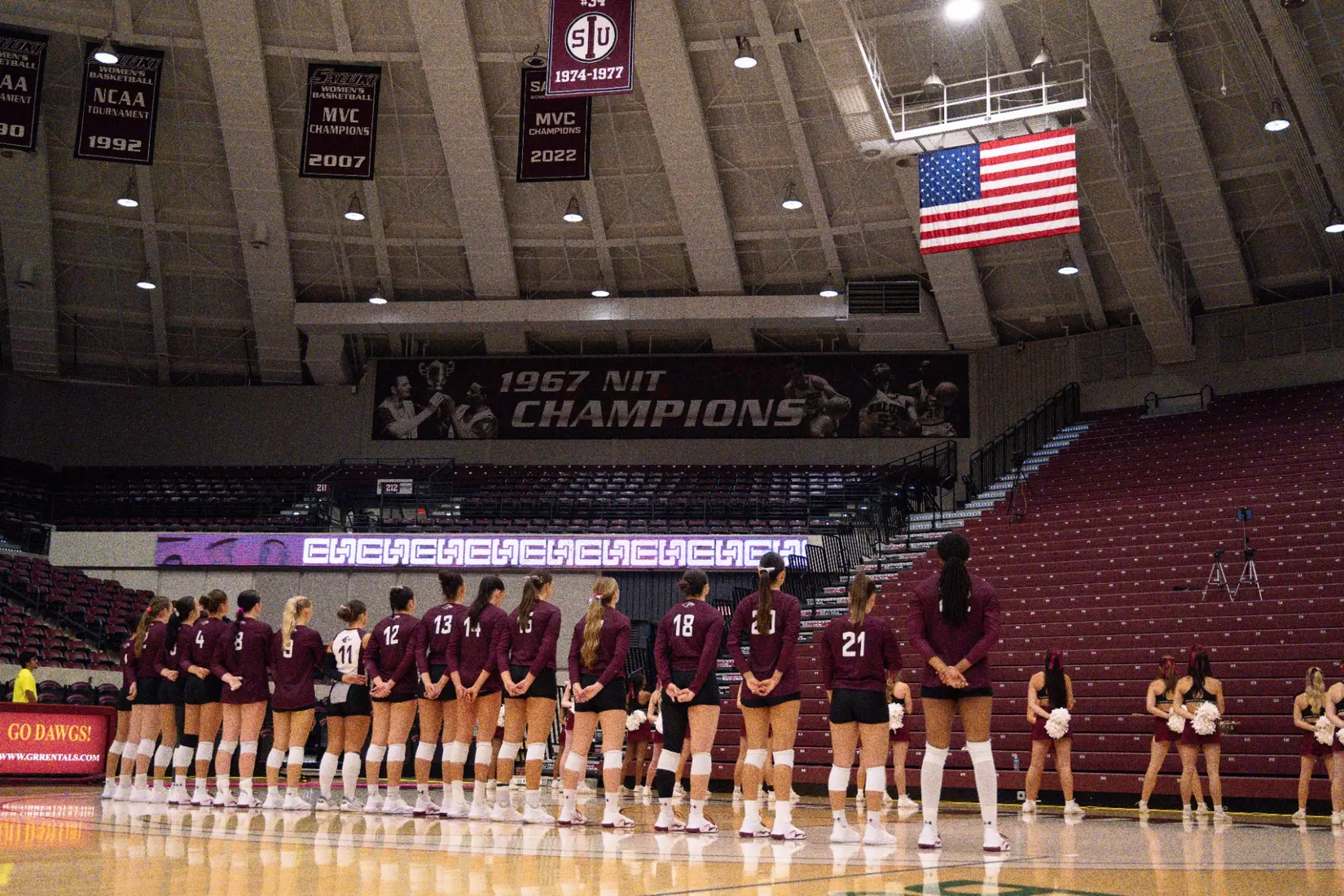 The team stands side-by-side during the National Anthem.