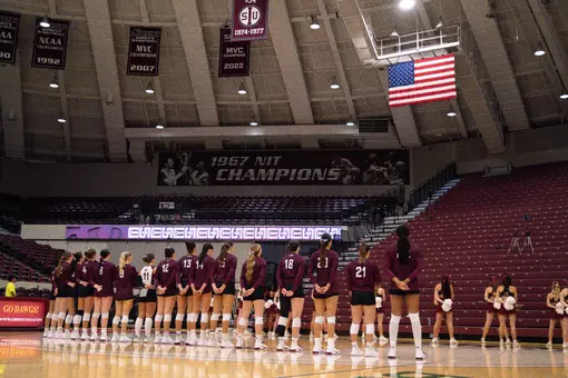 The team stands side-by-side during the National Anthem.