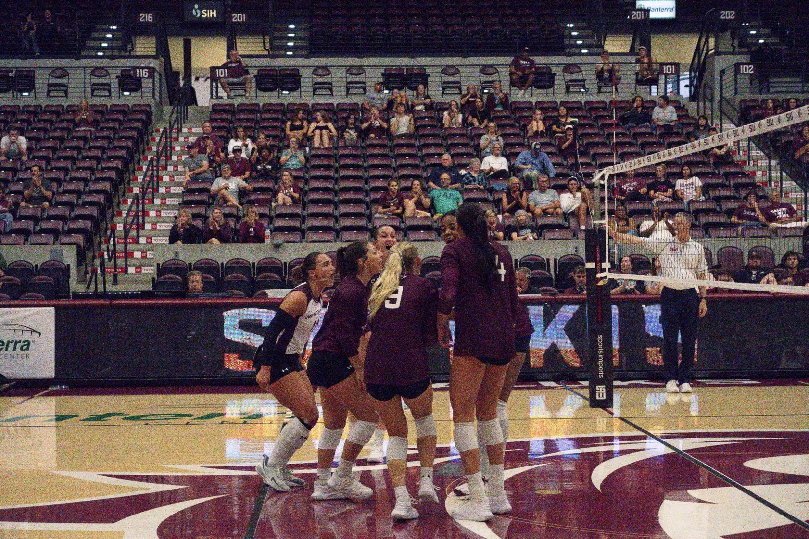 The team screams in celebration and huddles after a point.