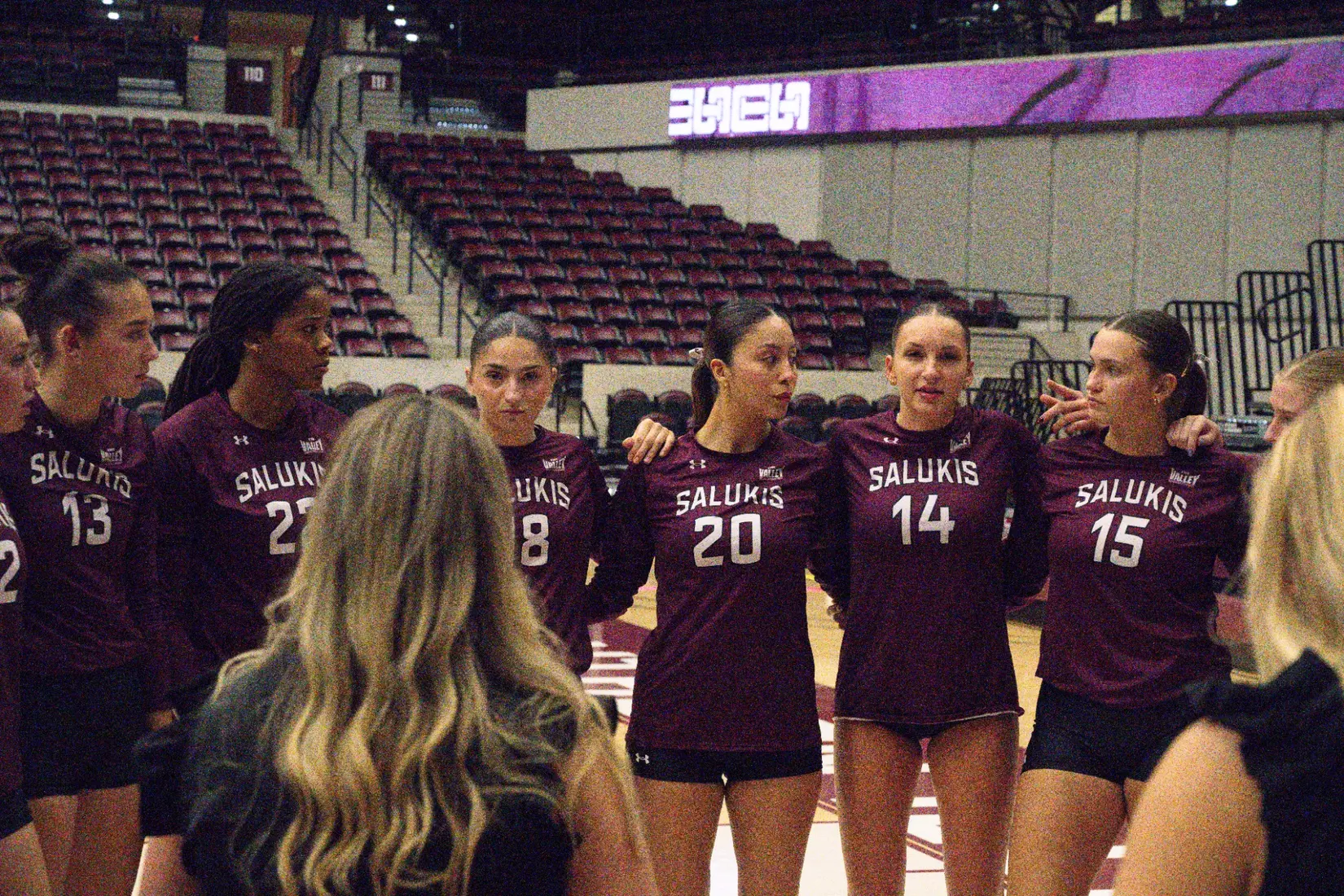 The team huddles around head coach Brittany Harry during a timeout.