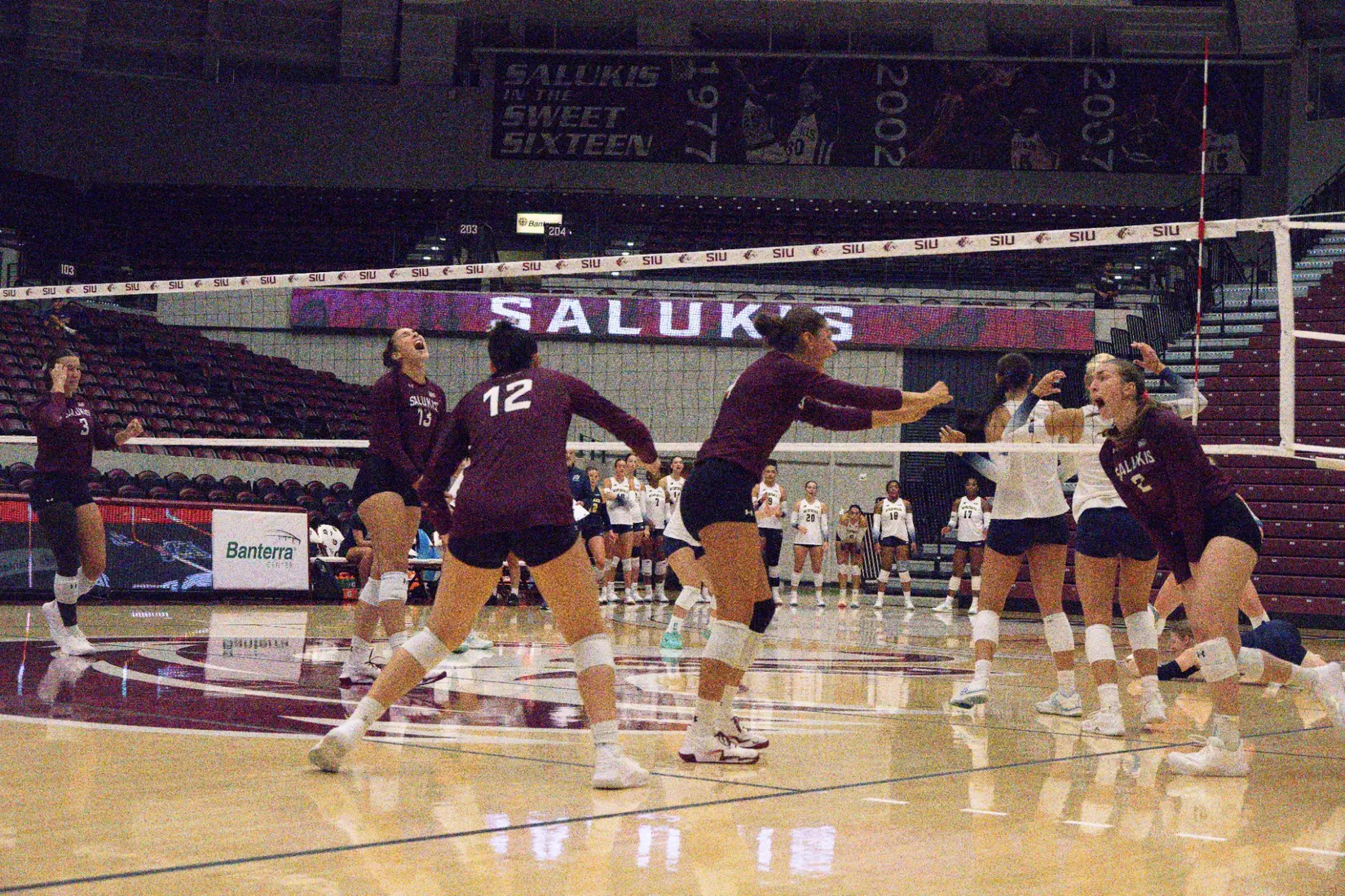 The team screams and runs in celebration after a point.
