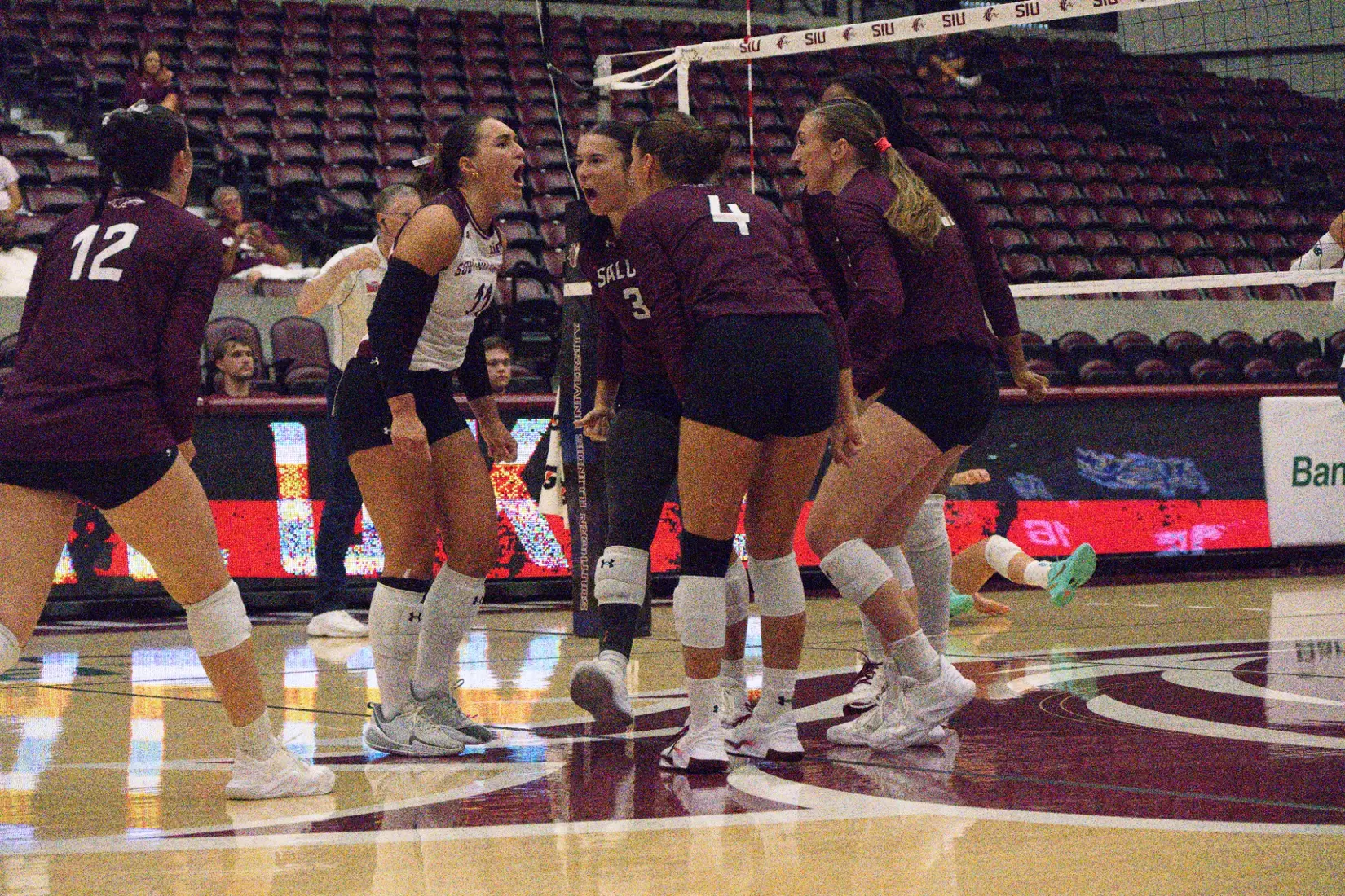 The team screams and huddles after a point.