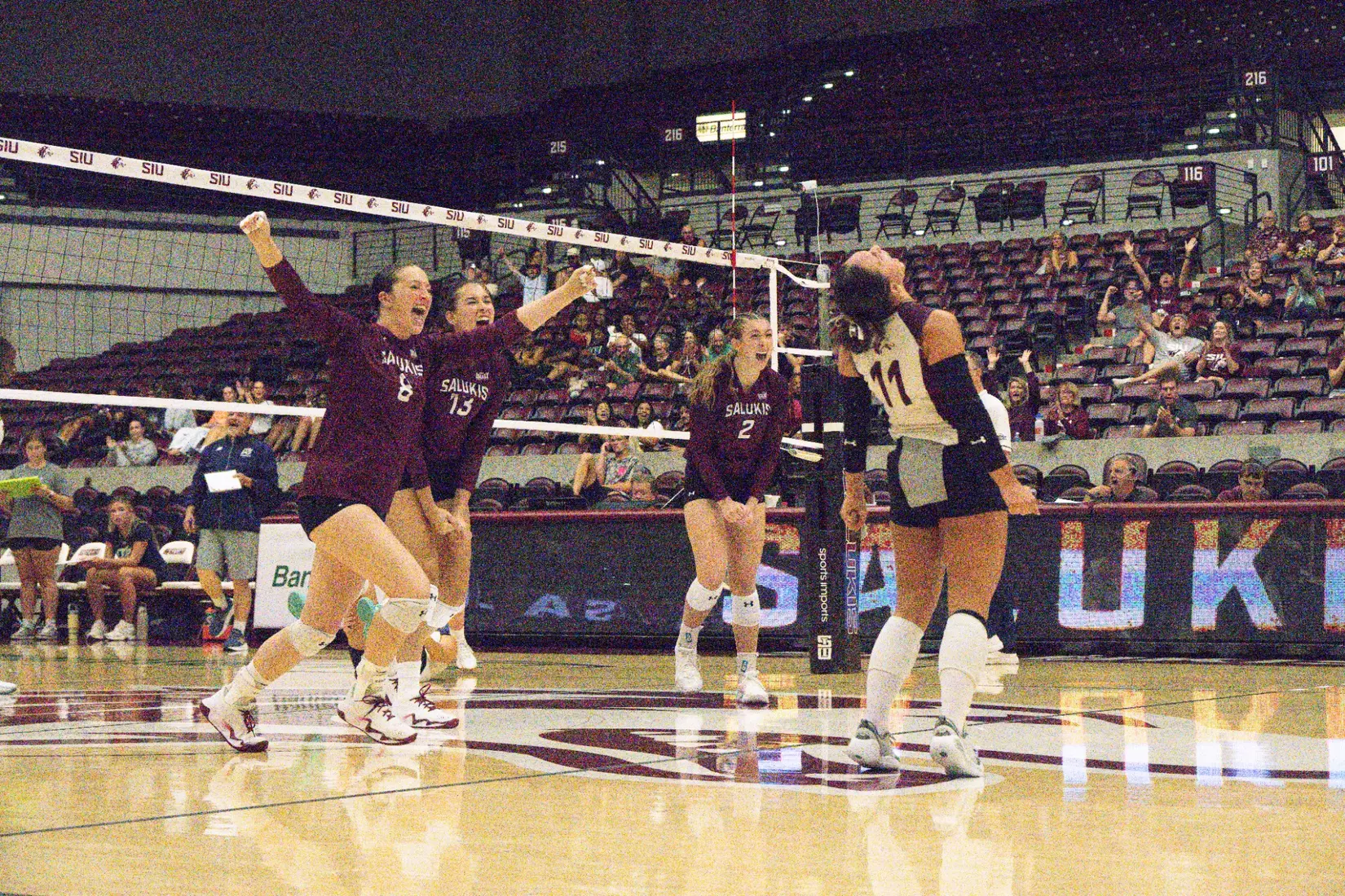 The team screams and runs in celebration after a point.