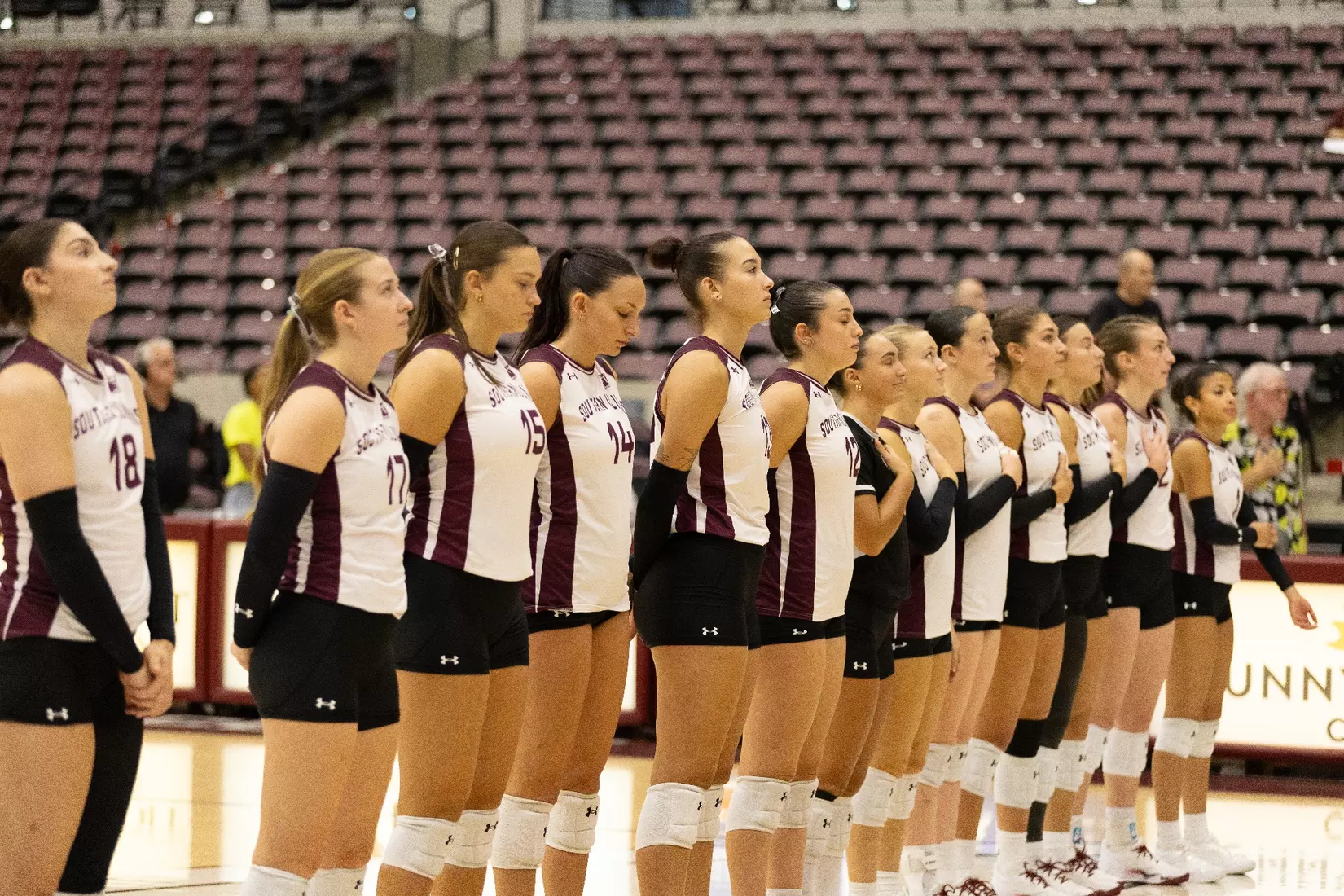 The team stands together during the national anthem.