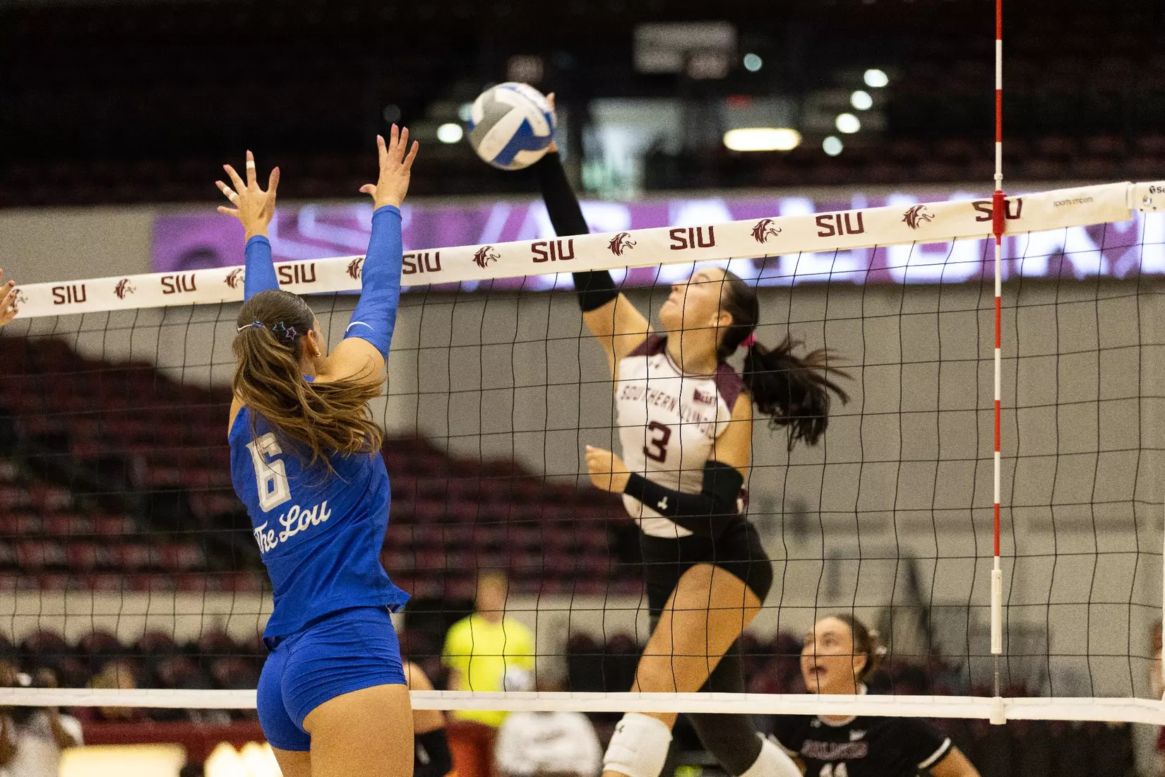 McKenzie Moeller spikes a ball over the net.
