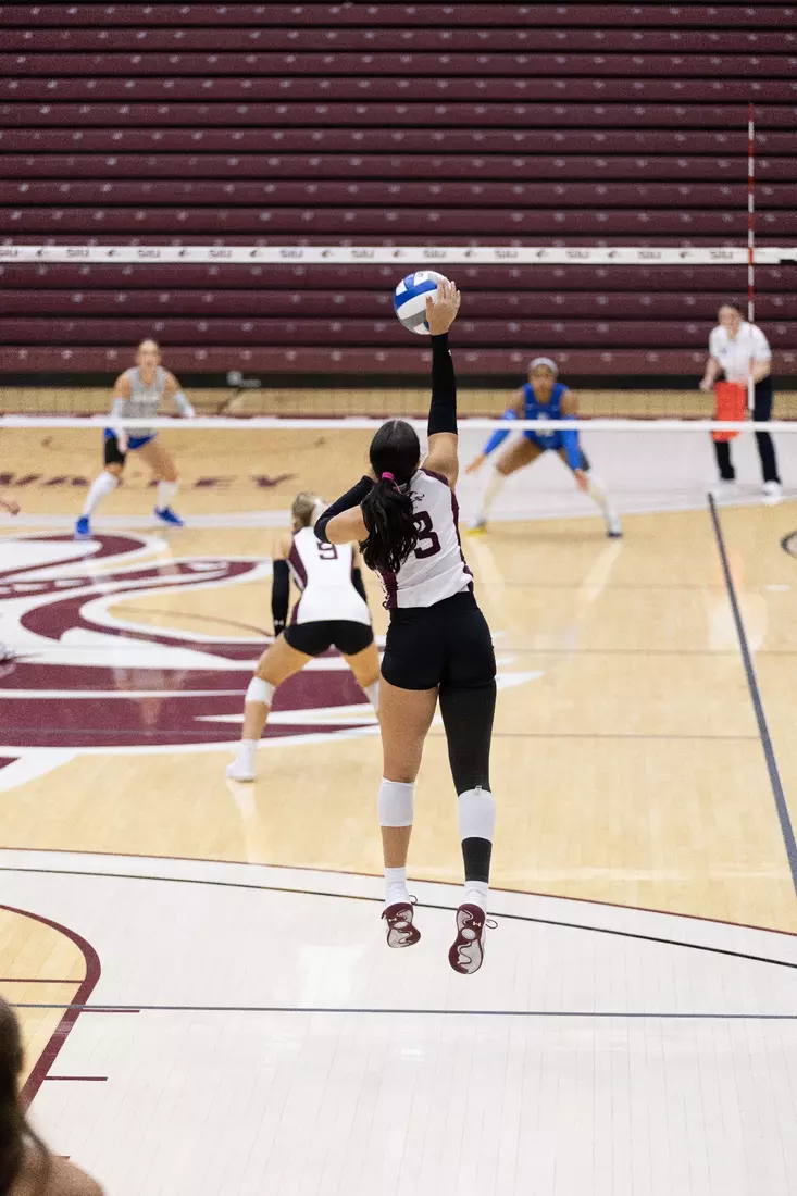 McKenzie Moeller jumps and serves a ball.