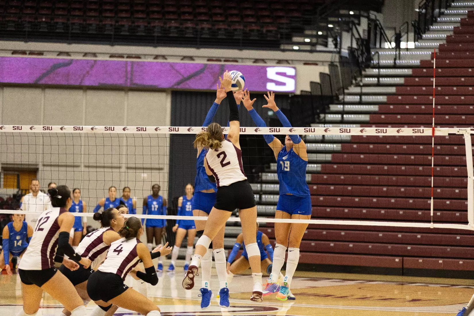 Natalie Vance spikes a ball over the blockers.