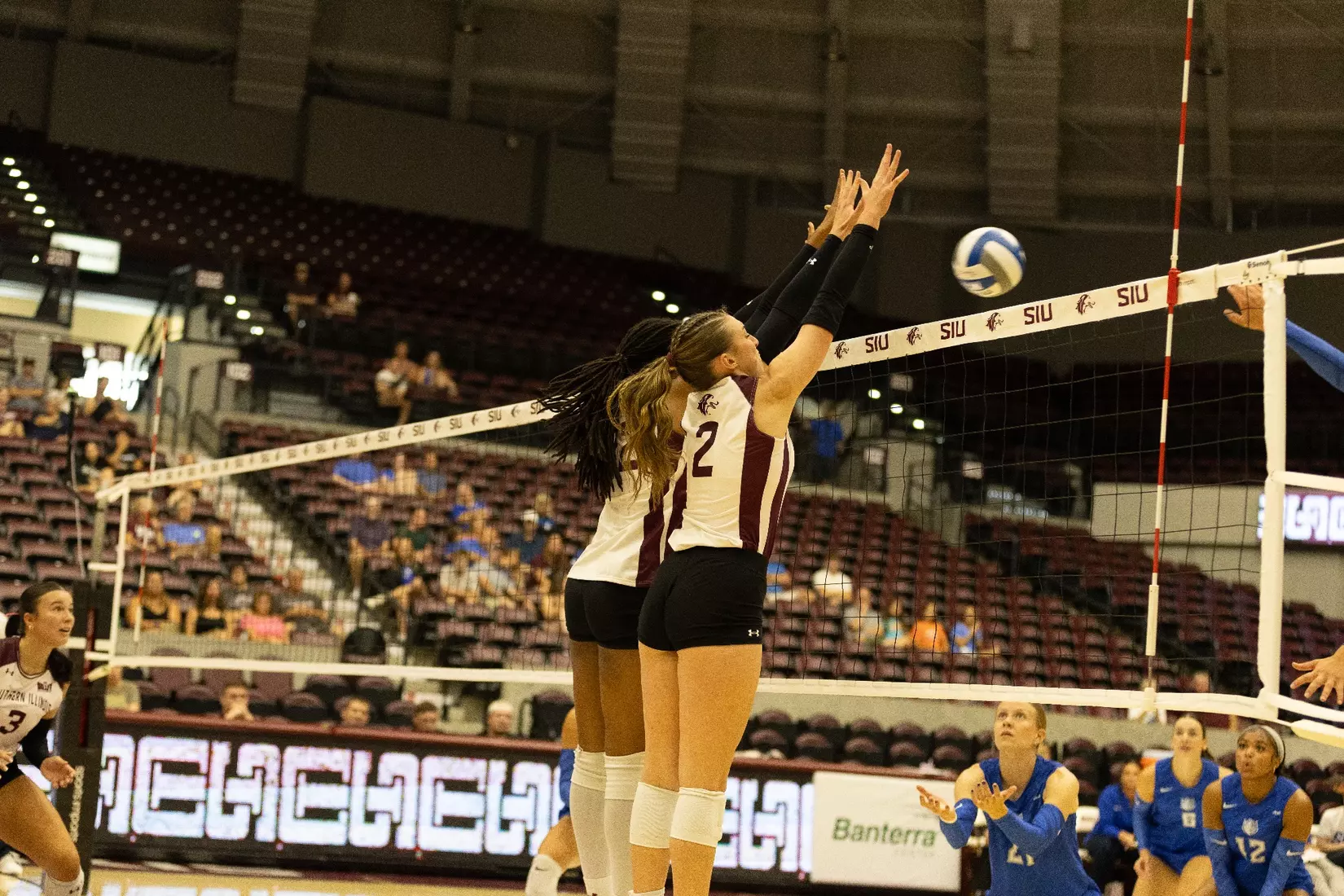 Chloe Anderson and Natalie Vance jump to block an incoming attack.