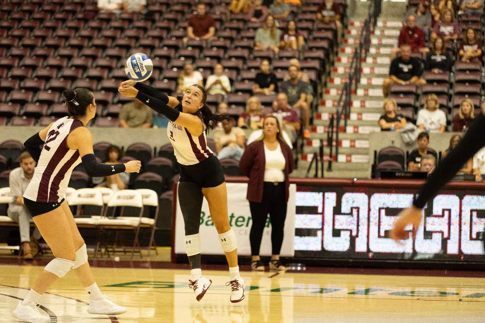 McKenzie Moeller jumps sideways to bump a ball.