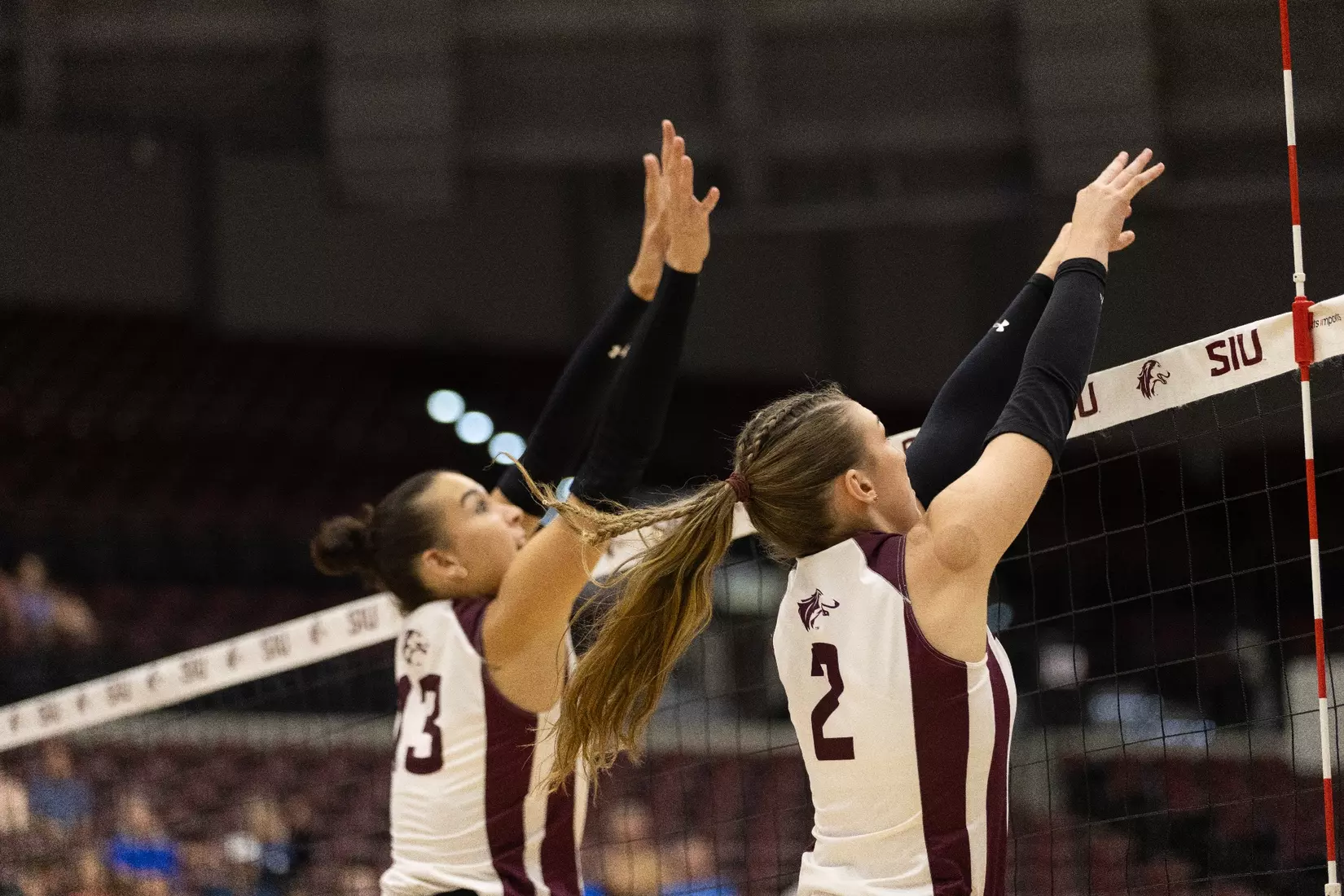 Beatriz Piaia and Natalie Vance jump up to block an incoming attack.