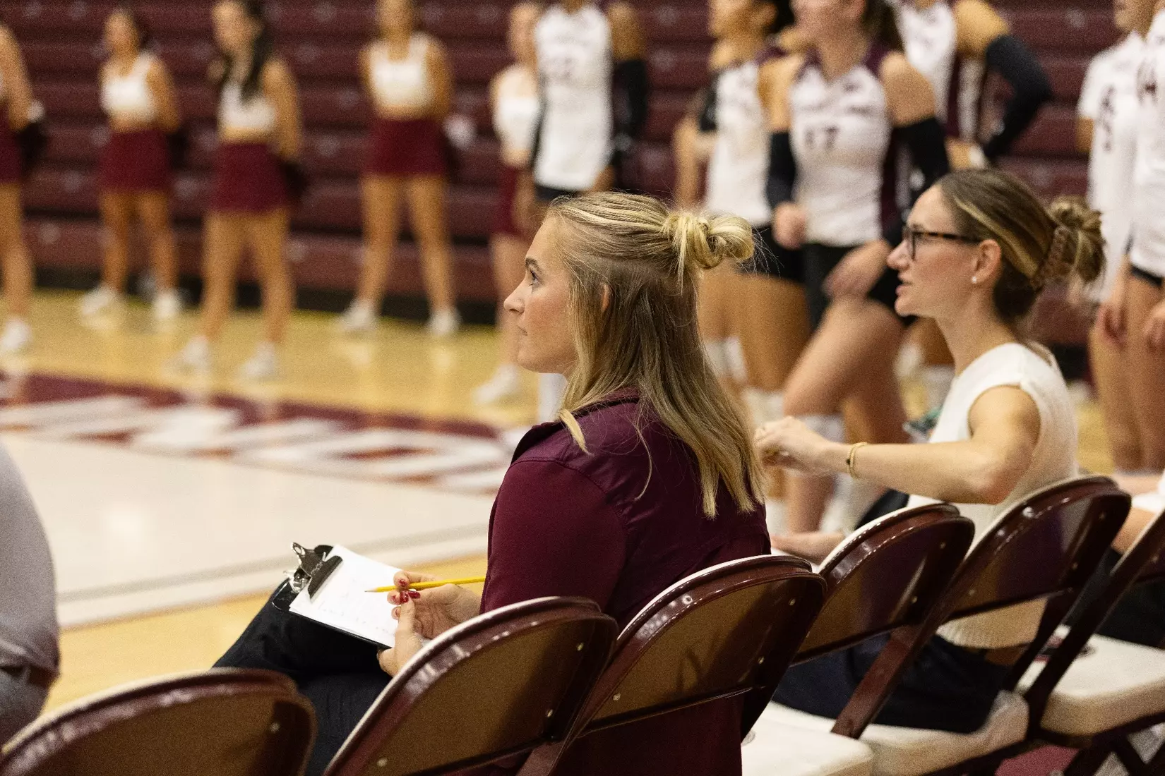 Graduate Assistant Emma Lade watches the match from the bench.