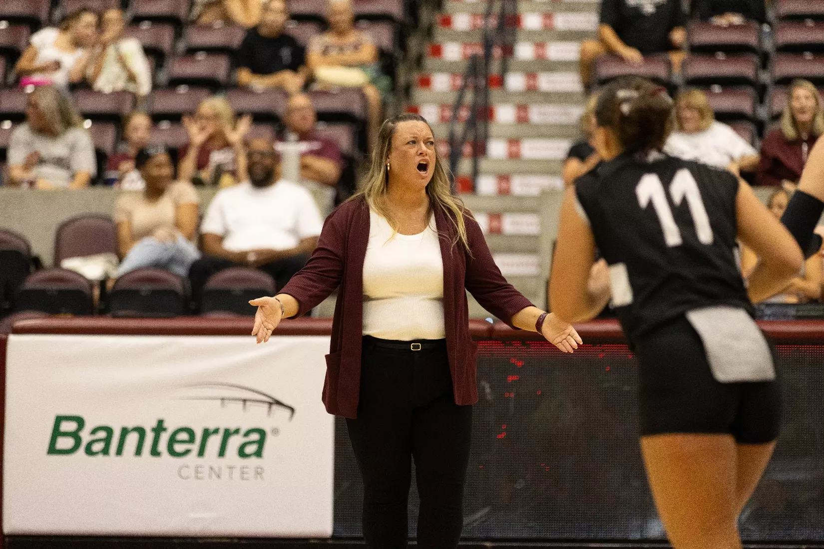 Head Coach Brittany Harry puts her hands out in confusion after a questionable call.