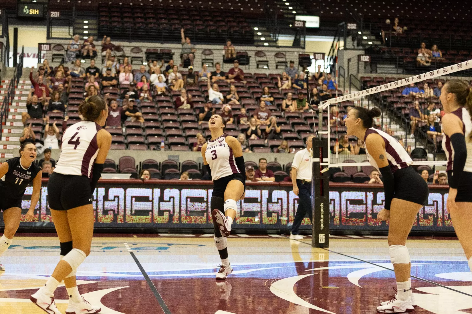 The team screams and celebrates after winning a set.