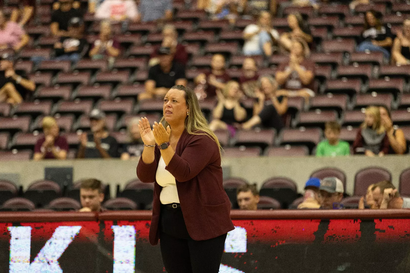 Head Coach Brittany Harry claps in support of her team.