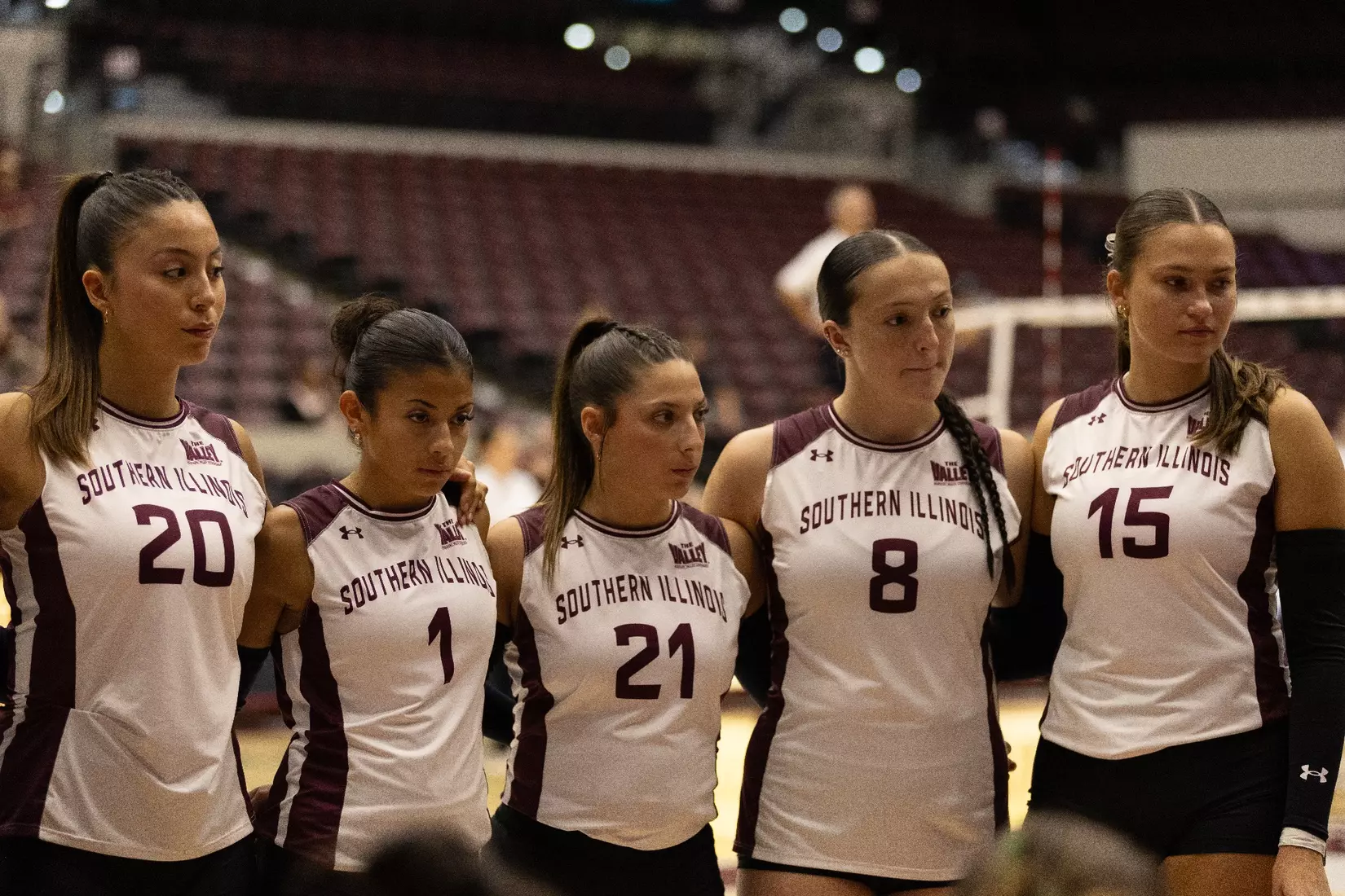 Members of the team hold each other in a huddle during a timeout.