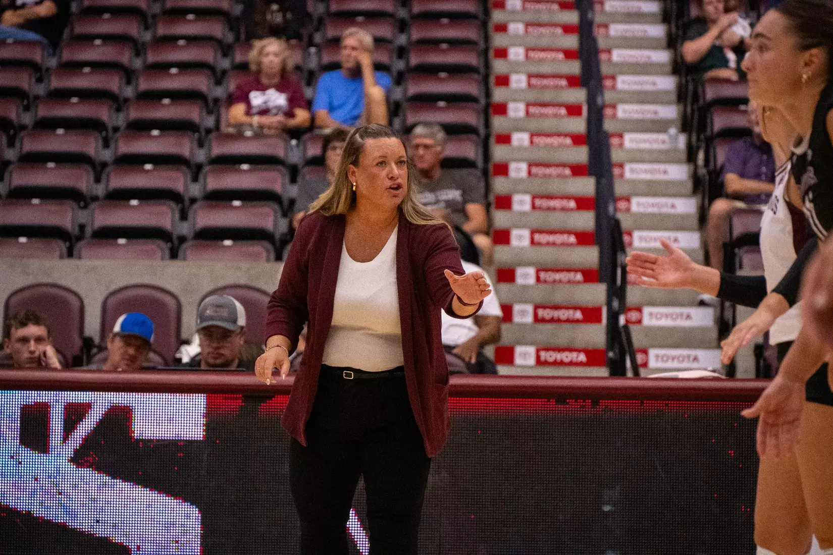 Head Coach Brittany Harry gives feedback to her team on the sideline.