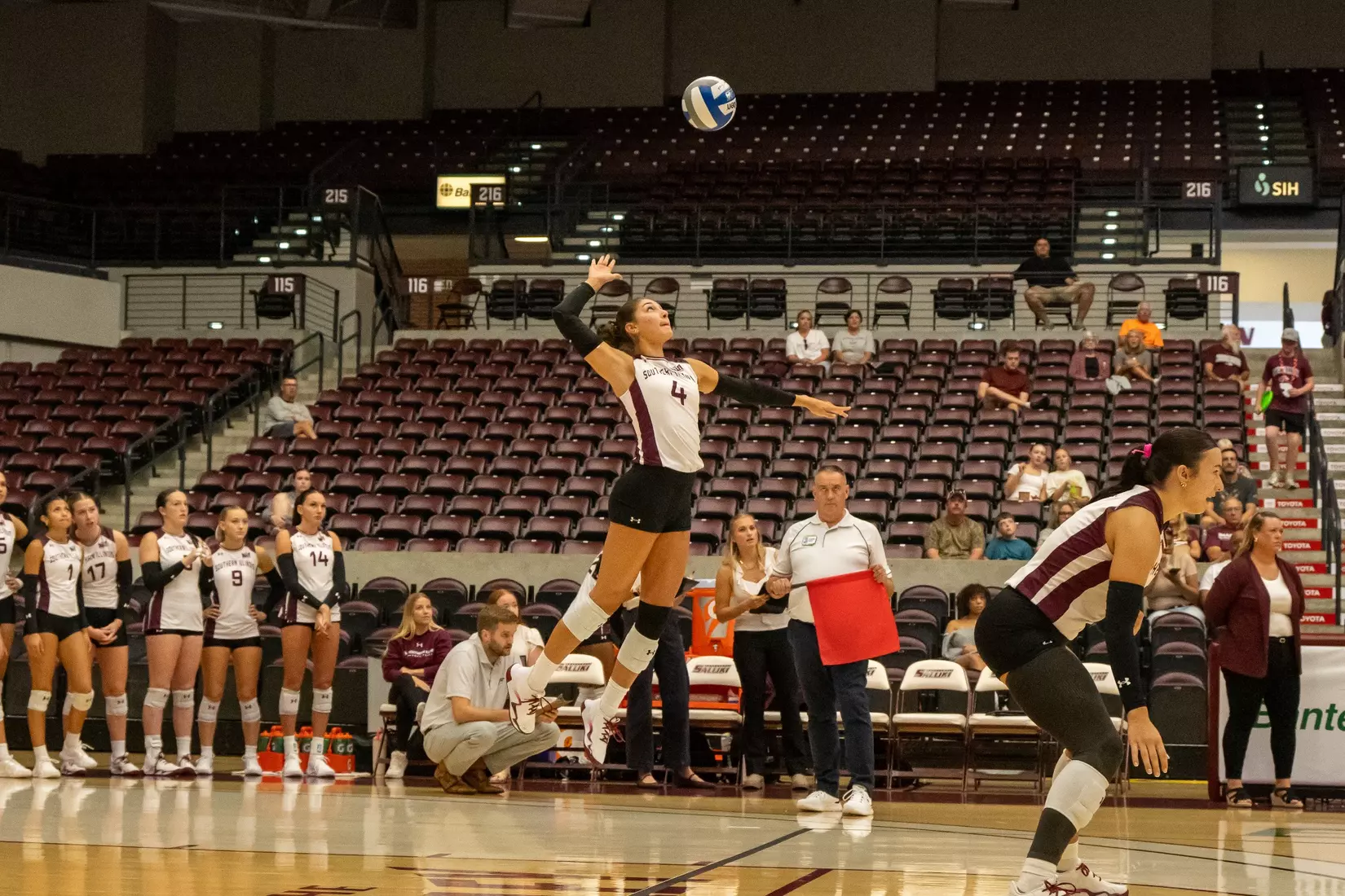 Ella McFarland jumps in the air as she serves a ball.