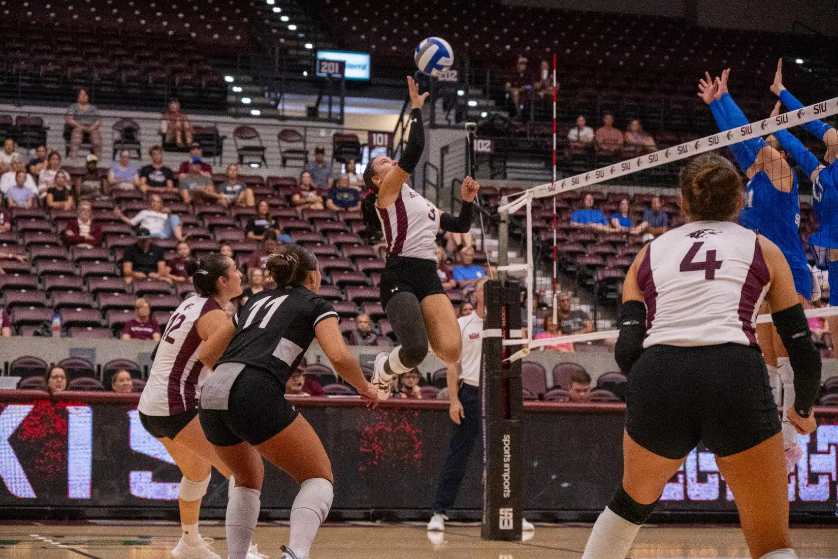McKenzie Moeller tips a ball over the net.