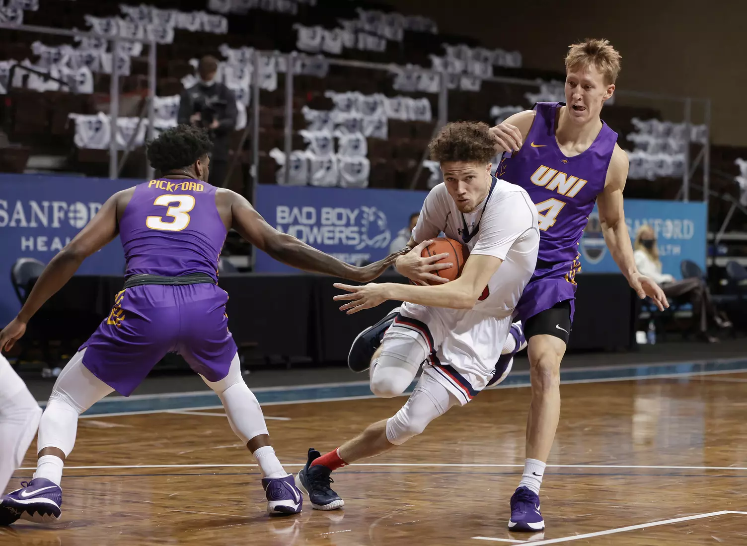 Logan Johnson #0 of the St. Mary's Gaels drives past Tywhon Pickford #3 and AJ Green #4 of the Northern Iowa Panthers during the Bad Boy Mowers Crossover Classic at the Sanford Pentagon in Sioux Falls, SD. (Photo by Richard Carlson/Inertia)