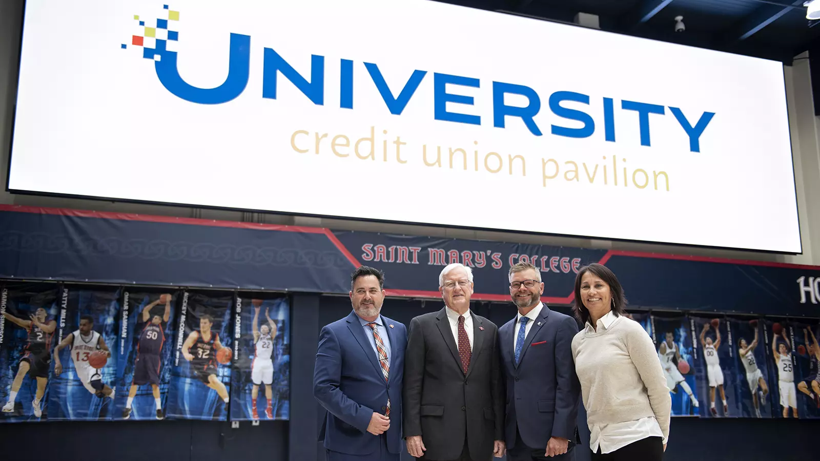 VP for Intercollegiate Athletics Mike Matoso, Saint Mary's president James Donahue, UCU president and CEO David Tuyo, and West Coast Conference commissioner Gloria Nevarez in front of the video board.