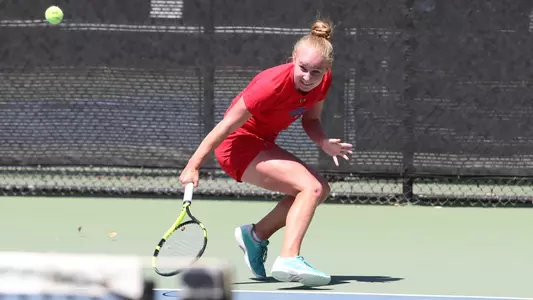 Kozyreva crouches down for a backhanded shot