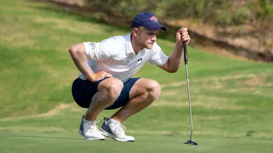 Kristian Bressum crouched down measuring putt