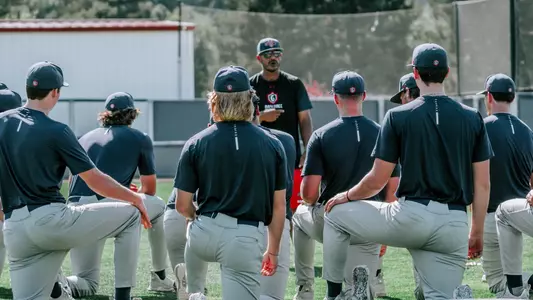 Coach Valenzuela talks to players at fall practice
